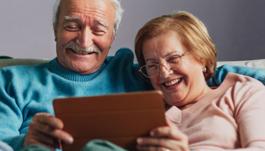 An elderly couple looking at a tablet